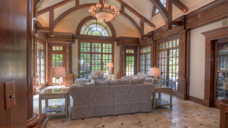 Classical Family Room addition in Geneva, Illinois: cherry-paneled family room with columns, dentil cornice, fanlight window and stone floor